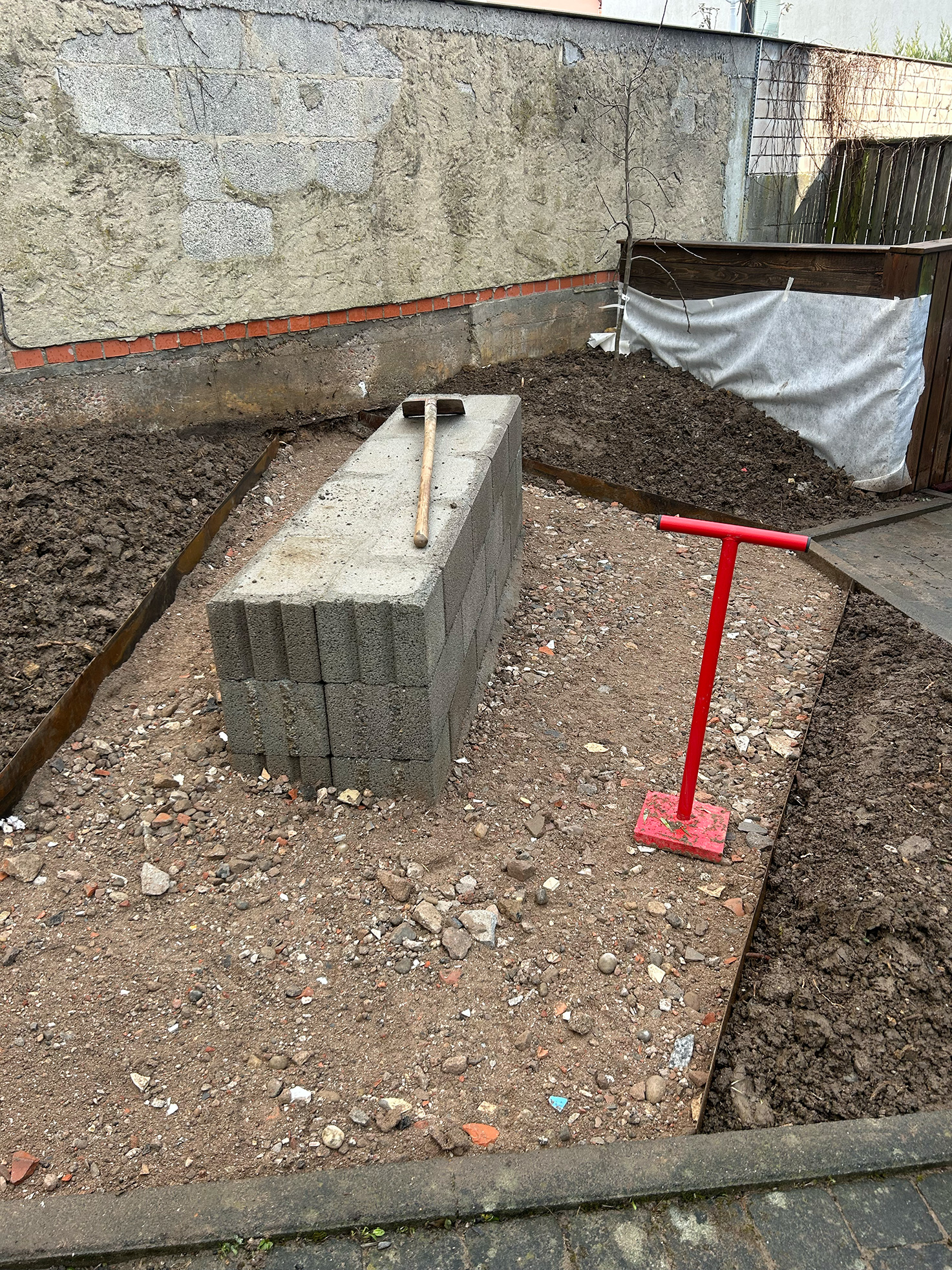 Betonblock mit Hammer auf vorbereiteter Fläche – Baustelle HIKITA Kita Sternenwelt.