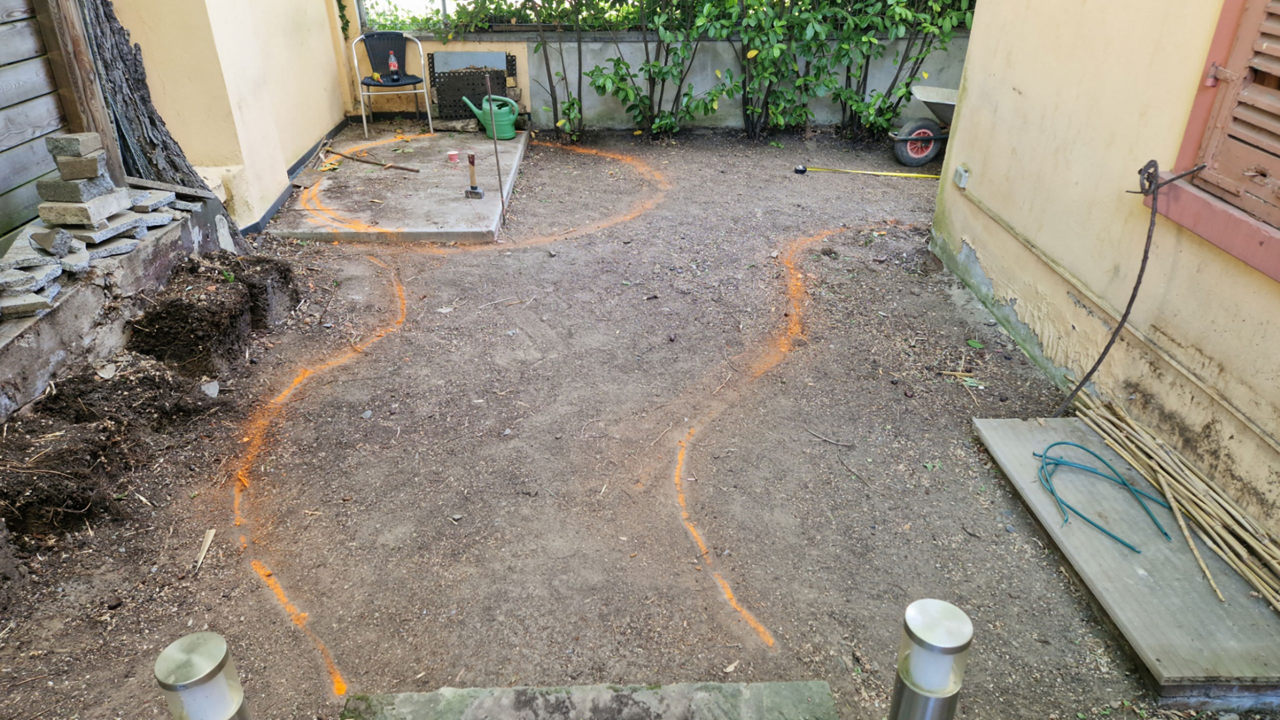 Baustellenansicht mit orange markierten Linien für Staudenbeete und Wege – Hinterhofgestaltung Frankfurt Nordend.