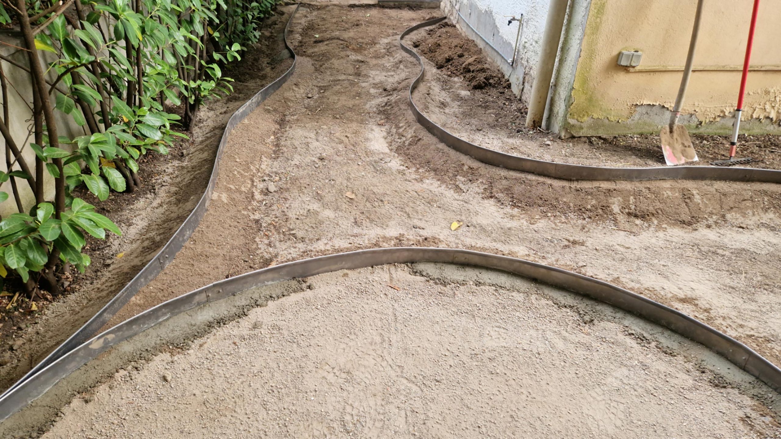 Baustelle mit geschwungenen Cortenstahl-Einfassungen für Staudenbeete und Wege – Projekt Nordend.“